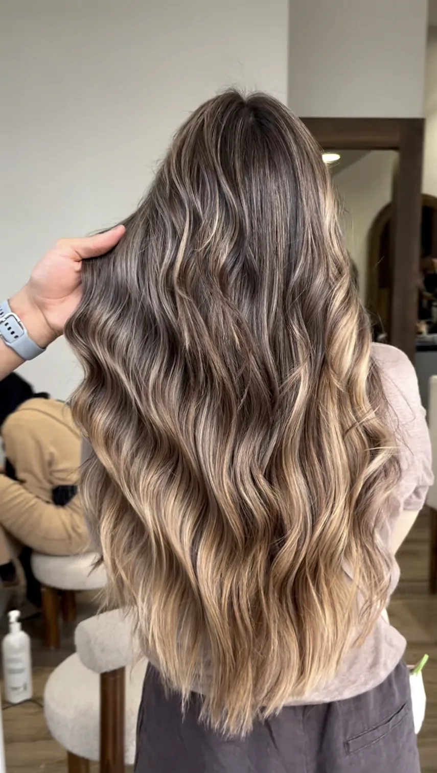 Balayage blond doré réalisé sur cheveux longs ondulés